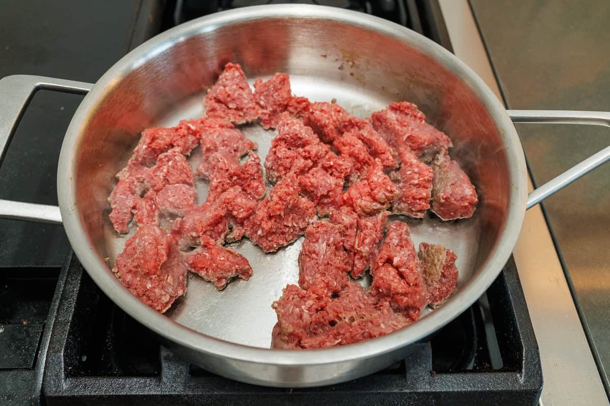 How to brown ground beef for Mexican Beef and Rice Skillet Ground beef browning in a skillet with a drizzle of olive oil