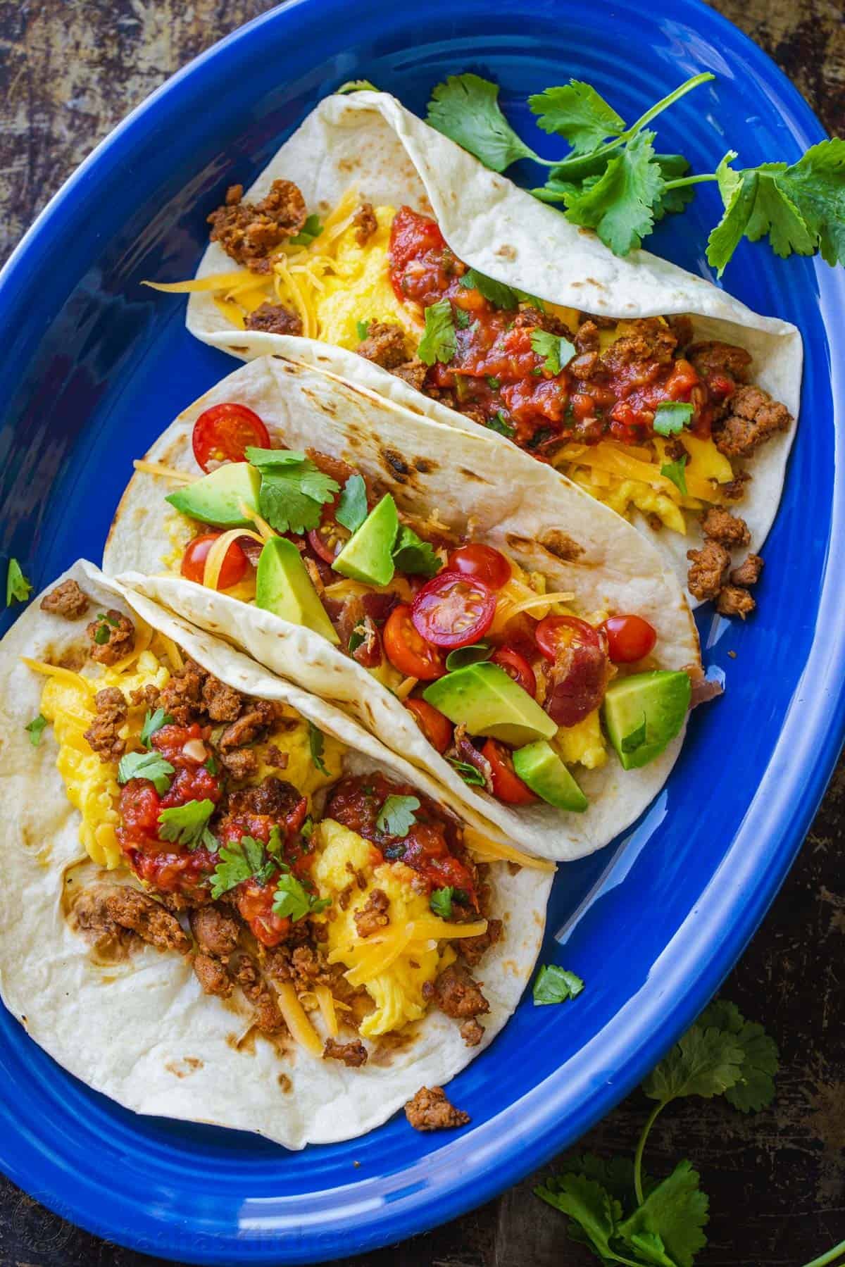 See our best breakfast ideas for busy weekday mornings and special holidays alike. Try out both sweet treats and healthy breakfast recipes. Overhead view of three breakfast tacos with chorizo on a blue oval plate.