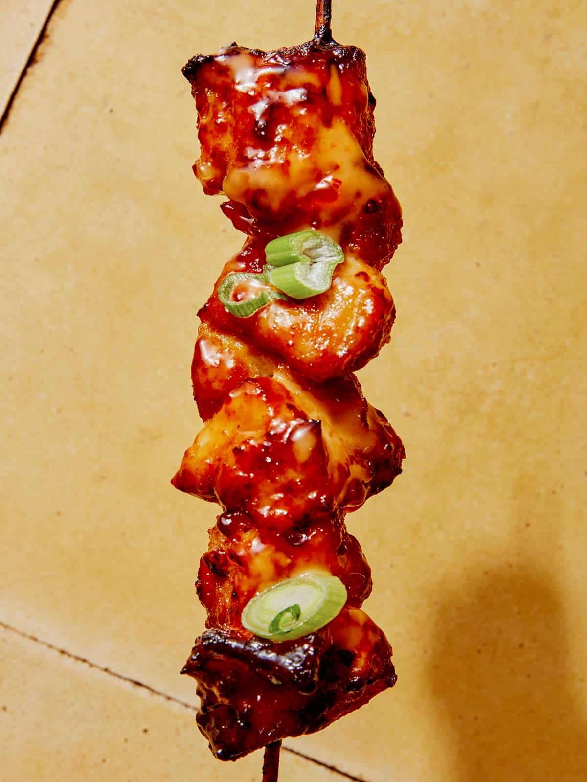 Close up on one air fryer bang bang chicken skewer.