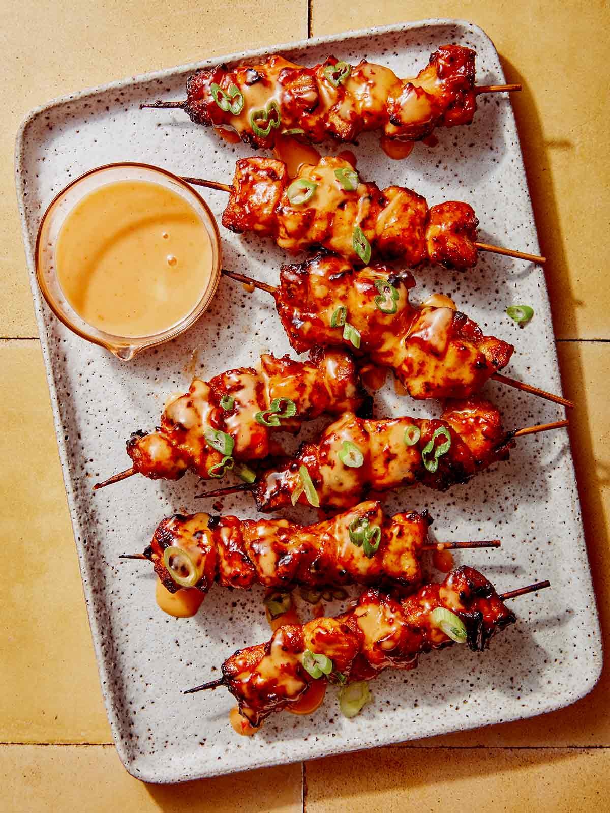 Air fryer bang bang chicken skewers with dipping sauce.