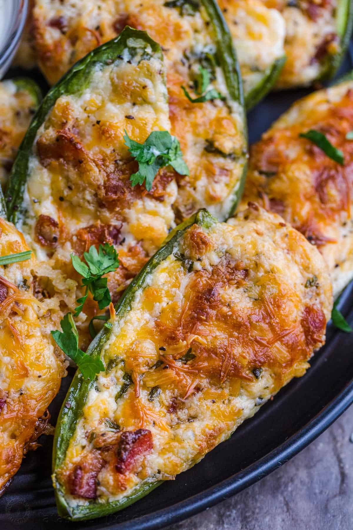 Jalapeno halves stuffed with bacon, cream cheese, and chives, baked until golden brown