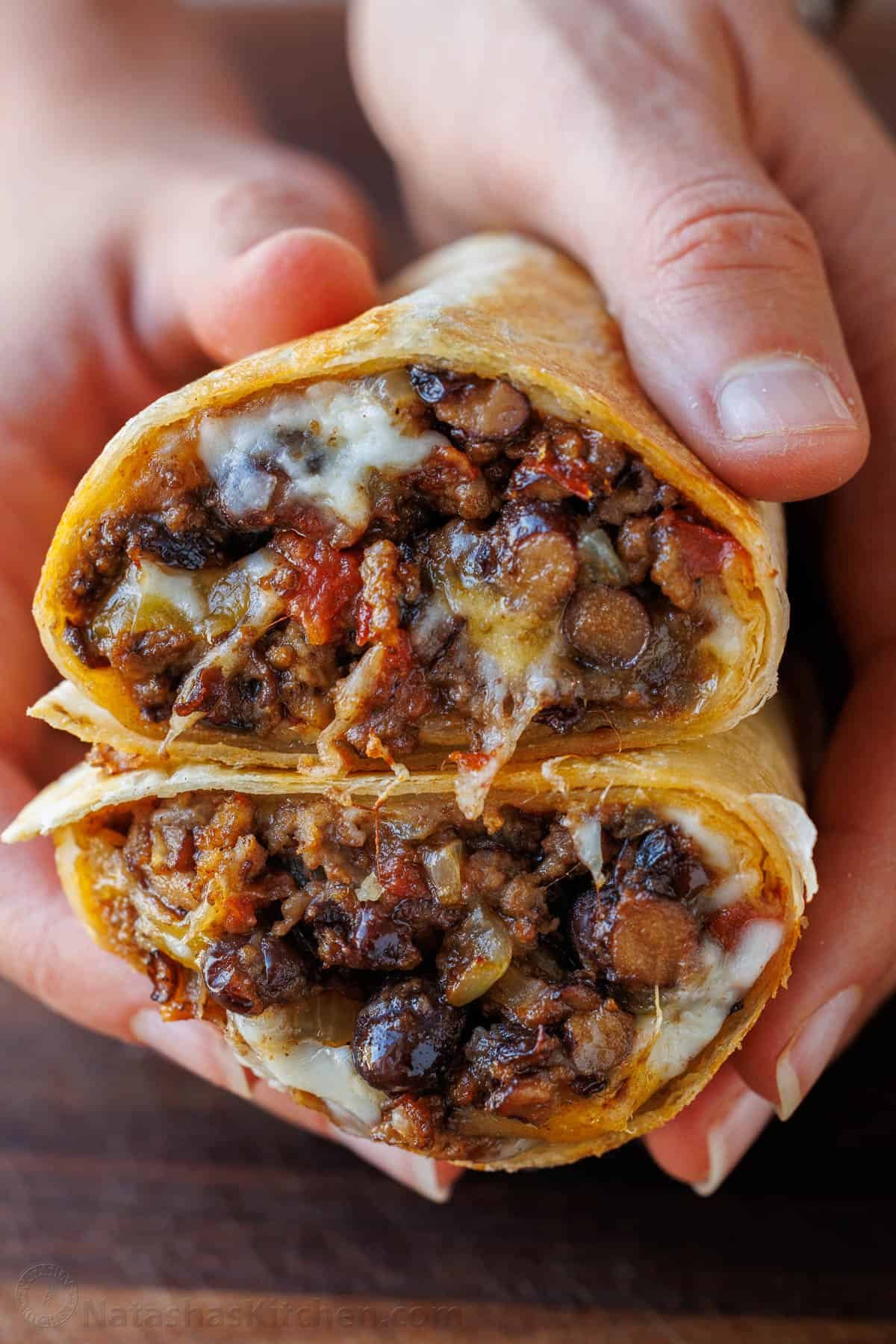 A Beef Burrito cut in half, stacked to showcase the ground beef, beans melted cheese, and tomatoes.