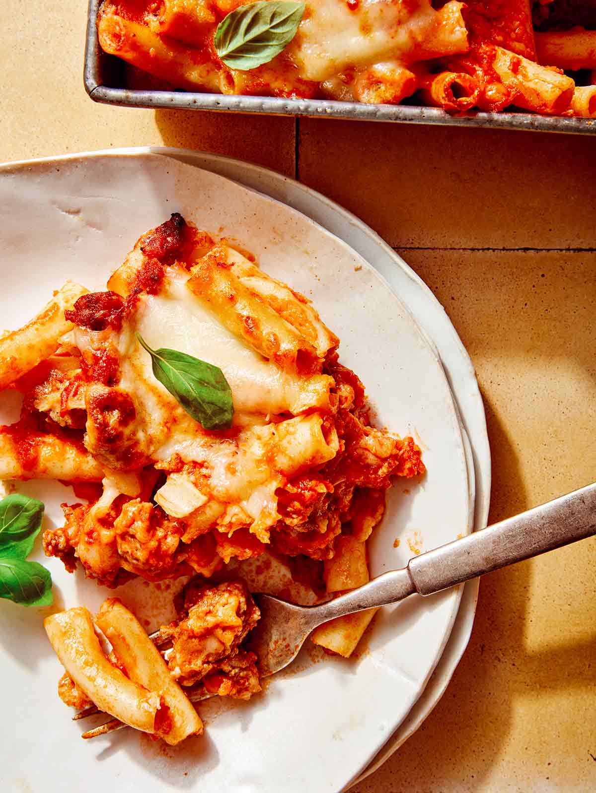 Baked ziti on a plate with a fork on it.