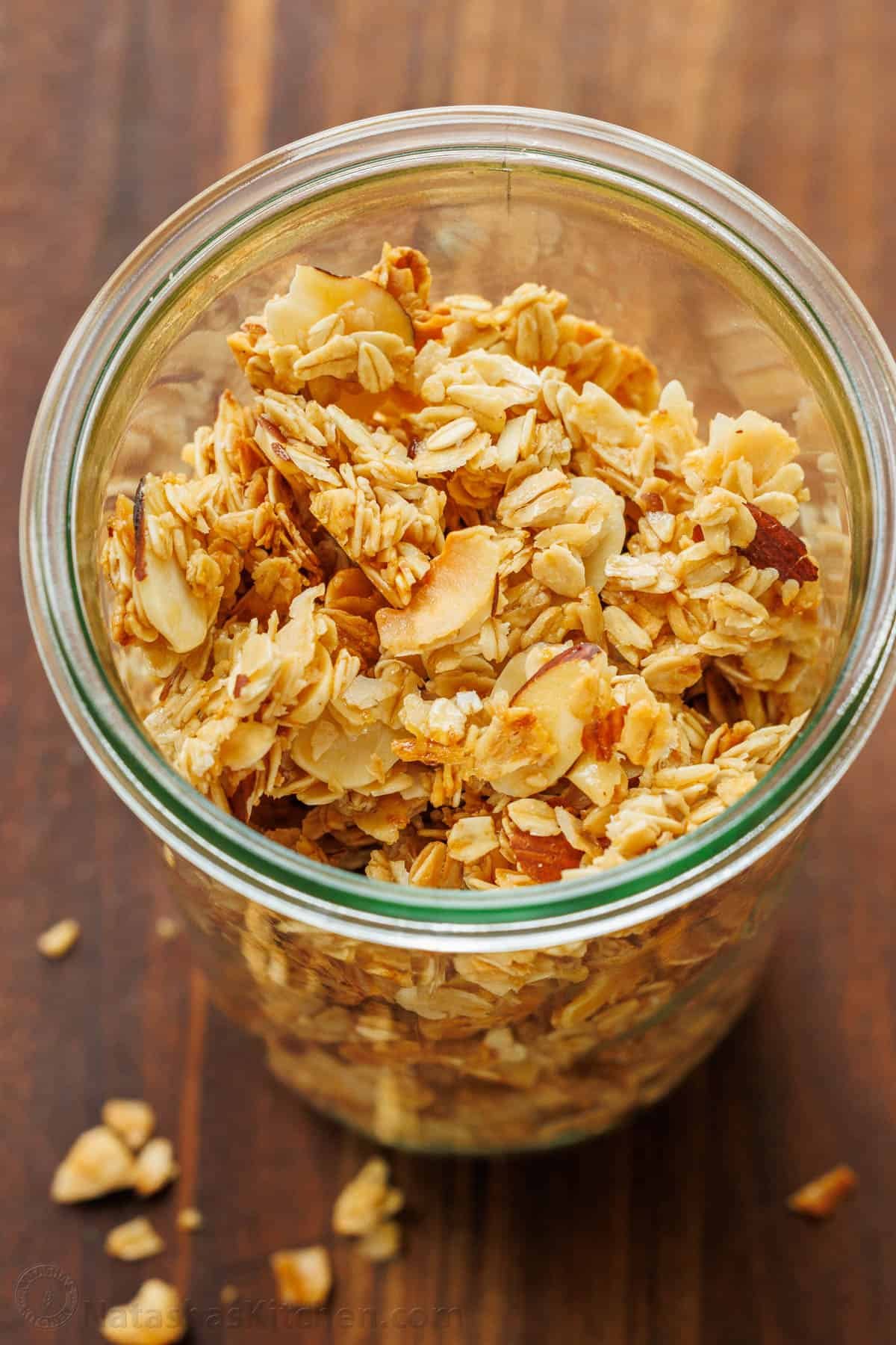 This Homemade Granola Recipe is one of my family's go-to healthy breakfast recipes because it's quick to make and ready to eat all week long. Homemade Granola in a clear jar with almonds and oats