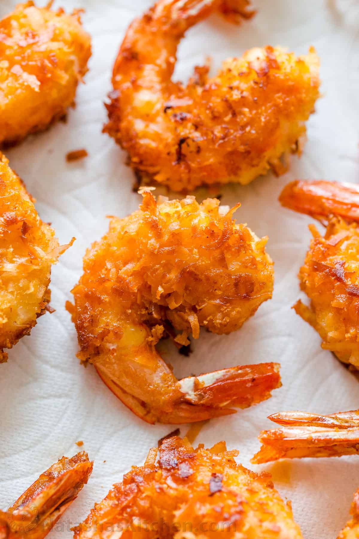Fried coconut shrimp resting on paper towel