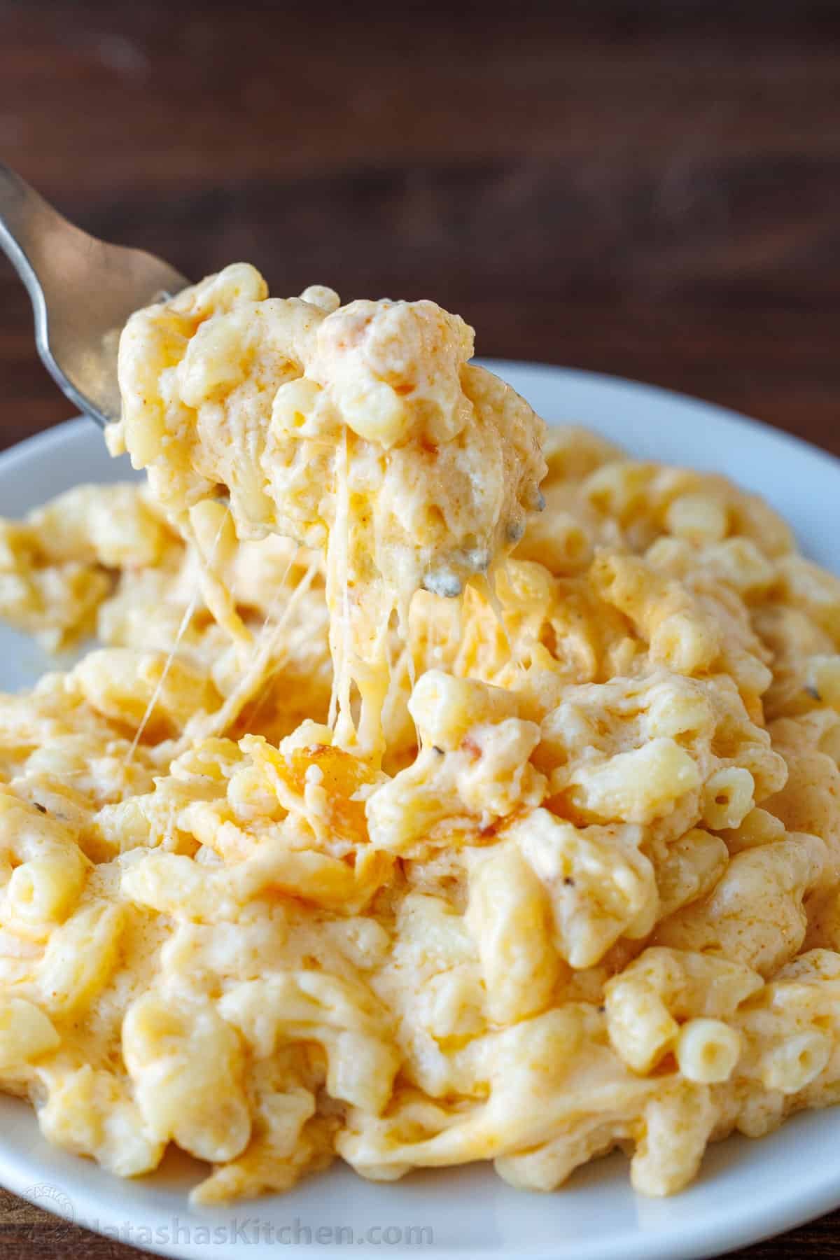 My Easy homemade Baked Mac and Cheese swaps the breadcrumbs for a crowd-pleasing cheese topping. It's perfectly gooey and easy to make. Baked Mac and Cheese on a white plate with a fork
