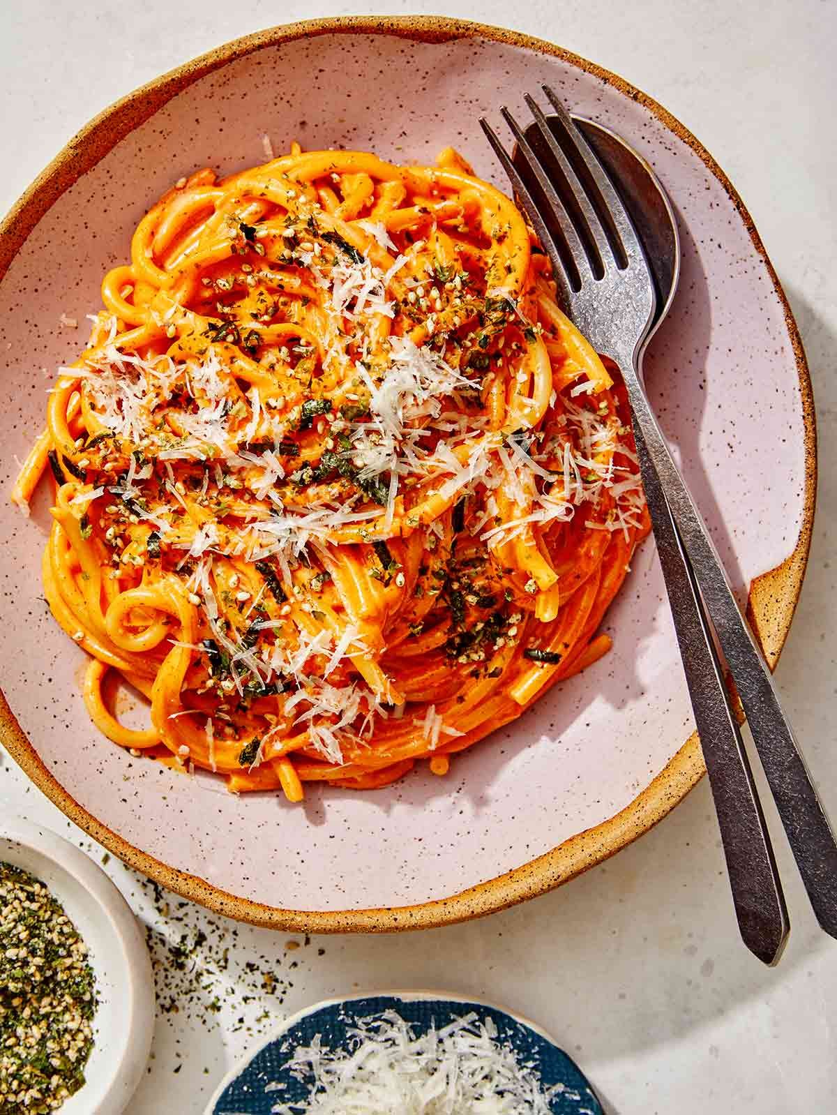 Gochujang noodles in a bowl with a fork on the side.