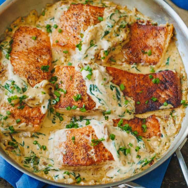 Tuscan Salmon served in a skillet with creamy sauce