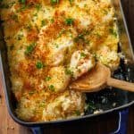 Top view of shrimp casserole recipe with toasted breadcrumbs and a wood spoon