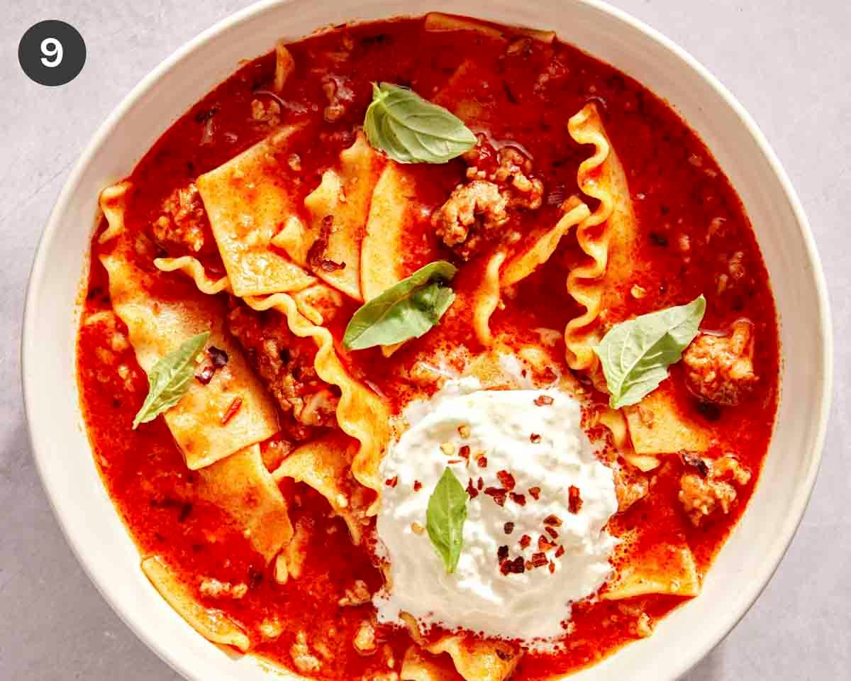 Lasagna soup with garnish like red pepper flakes and basil on top.
