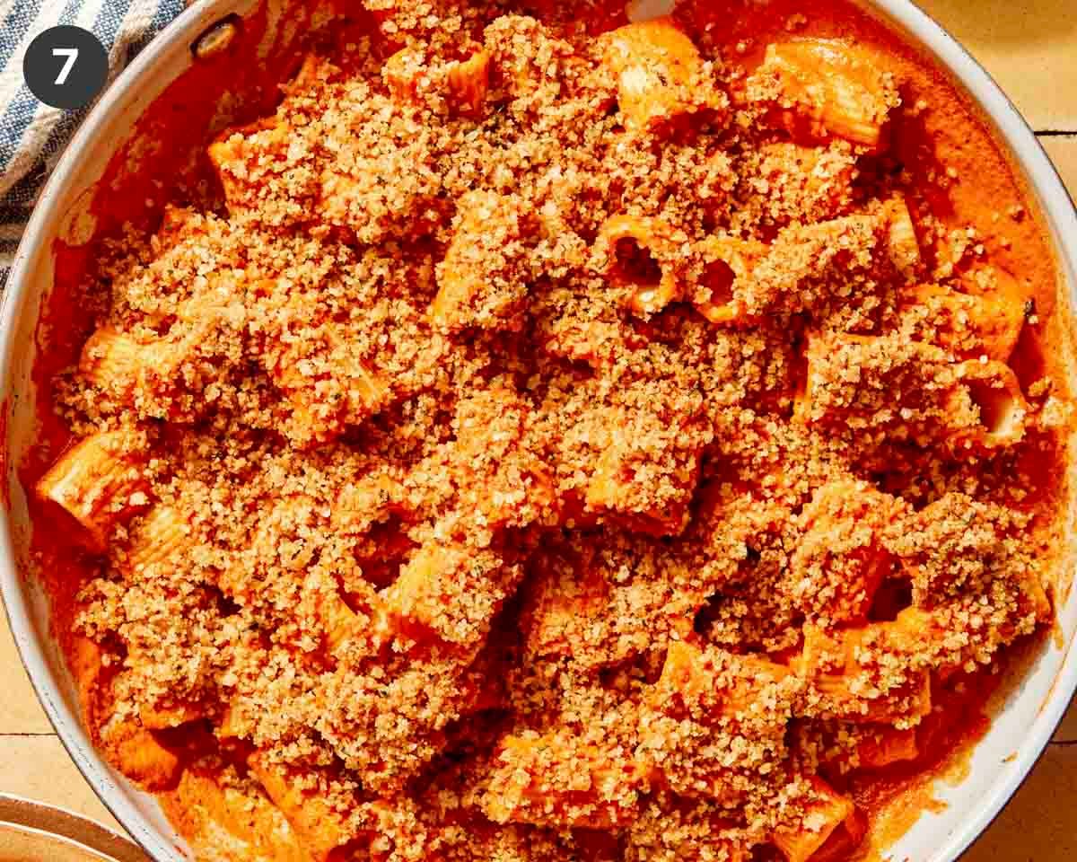 Close up in a skillet of romesco sauce with breadcrumbs on top.