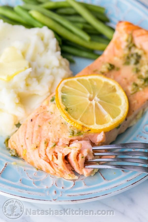A plate with salmon, mashed potatoes and green beans 
