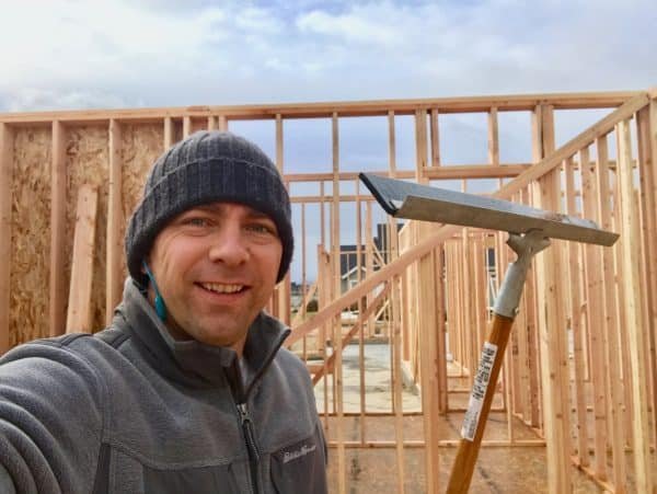 A man standing in front of a wooden structure