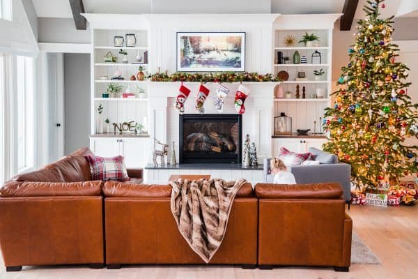 A living room filled with furniture, a fireplace and Christmas tree