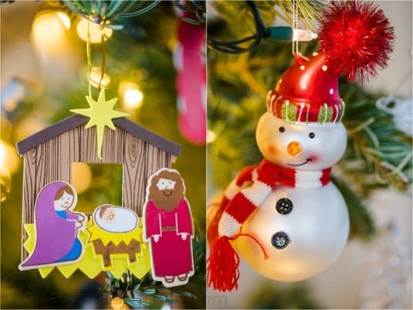 A close up of two ornaments, one of Jesus in a manger and another of snowman 