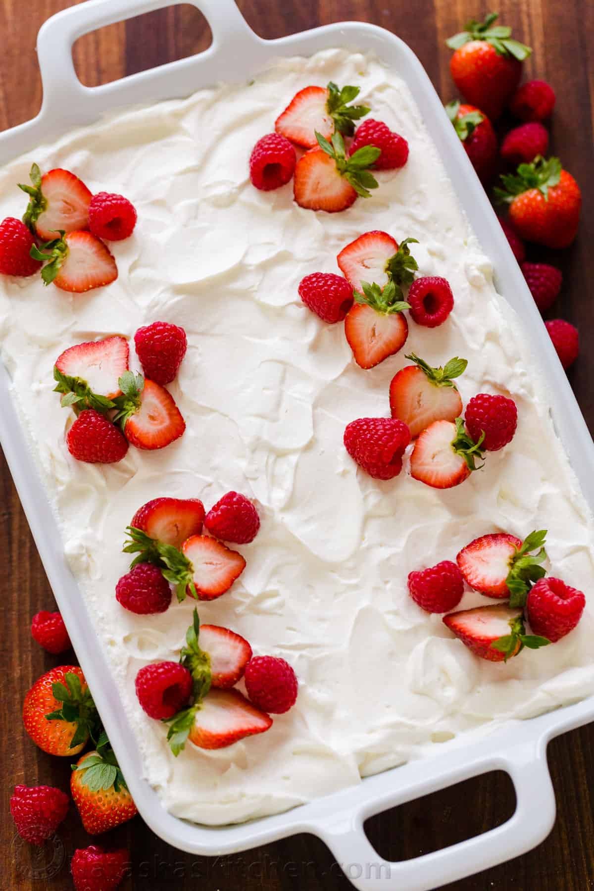Tres Leches Cake has a soft and ultra-moist crumb. This authentic Tres Leches Cake recipe is soaked with a 3 milk mixture and topped with whipped cream. #tresleches #treslechescake #treslechescakerecipe #mexicancake #cake #cakerecipe #moistcake #natashaskitchen Fully assembled tres leches cake ready for refrigeration