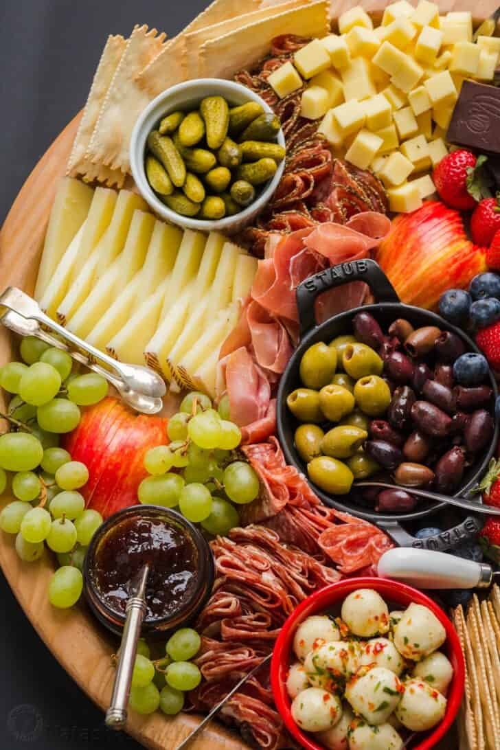 Making a Charcuterie Board is easier than you think. Sharing the best flavor pairings, and tips for arranging a meat and cheese board. Showing what is charcuterie with arrangement of cured meats and accompaniments
