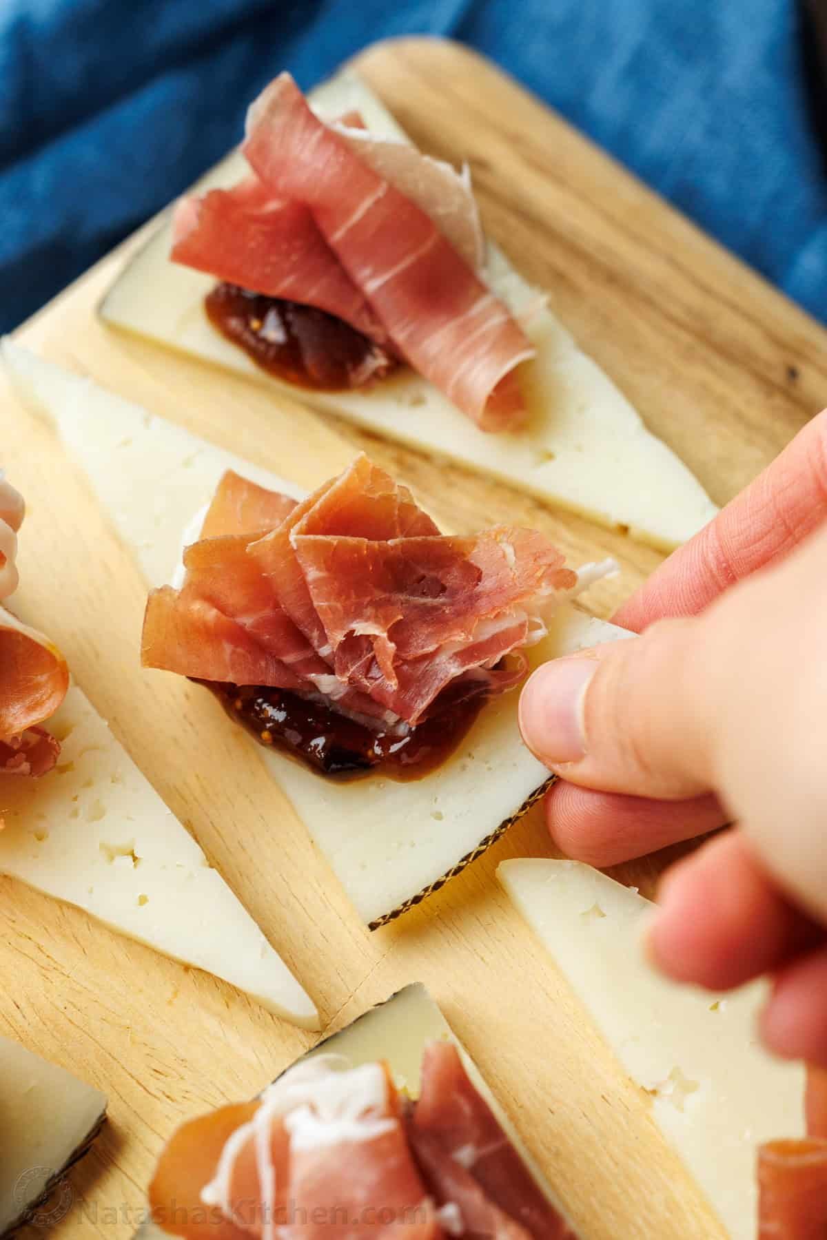 Easy manchego cheese bites with fig preserves and prosciutto take less than 5 minutes to make, but they look elegant and taste divine! Cheese appetizers with prosciutto and fig jam