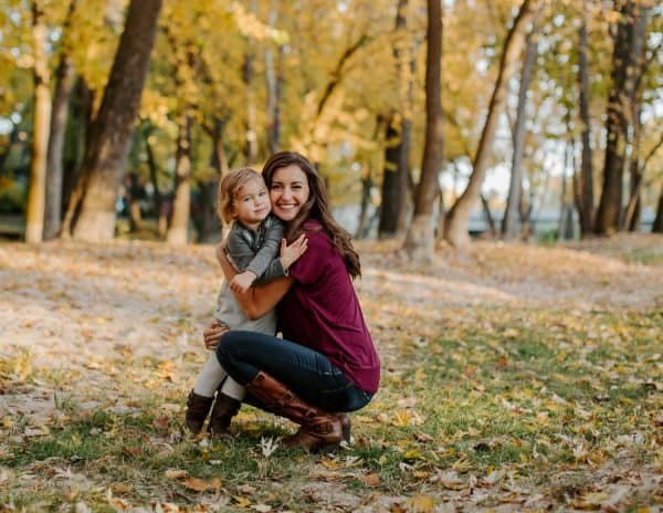 A mother and daughter hugging in a park