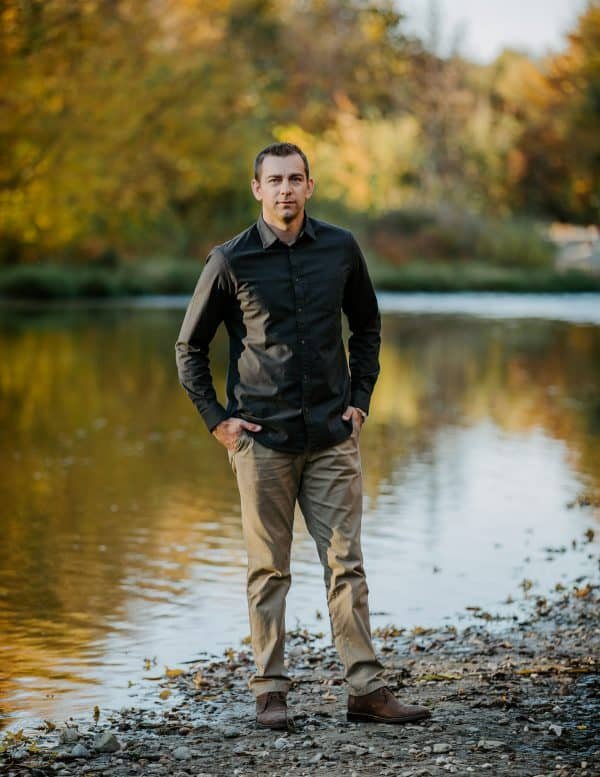 A man standing next to a river