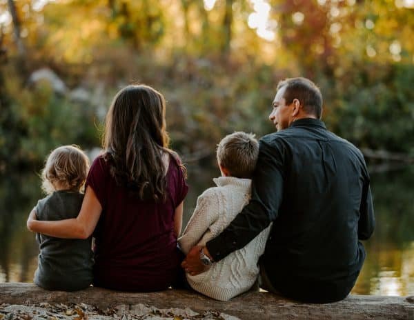 A family sitting on a log