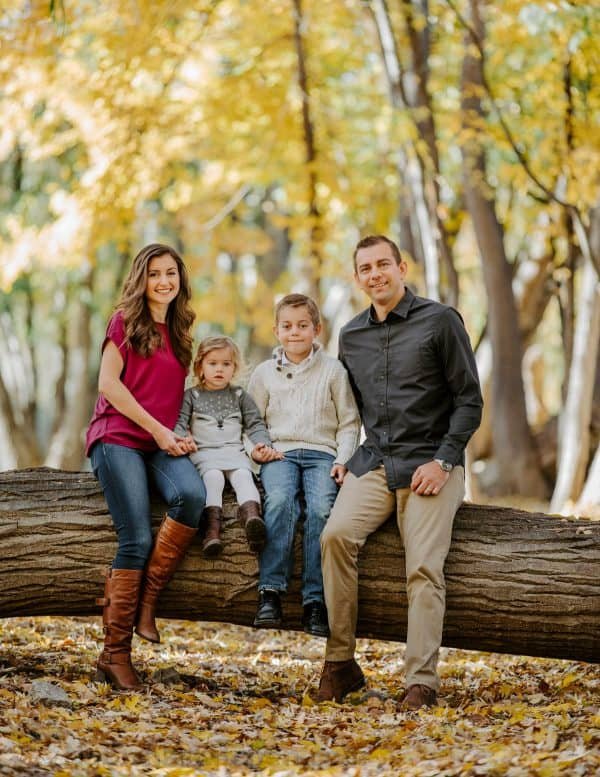 A family sitting on a tree log 