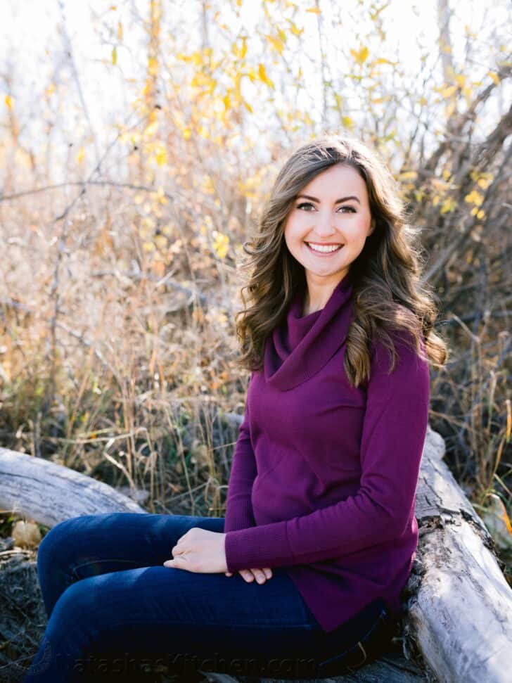 Natasha Kravchuk sitting on a log posing for the camera