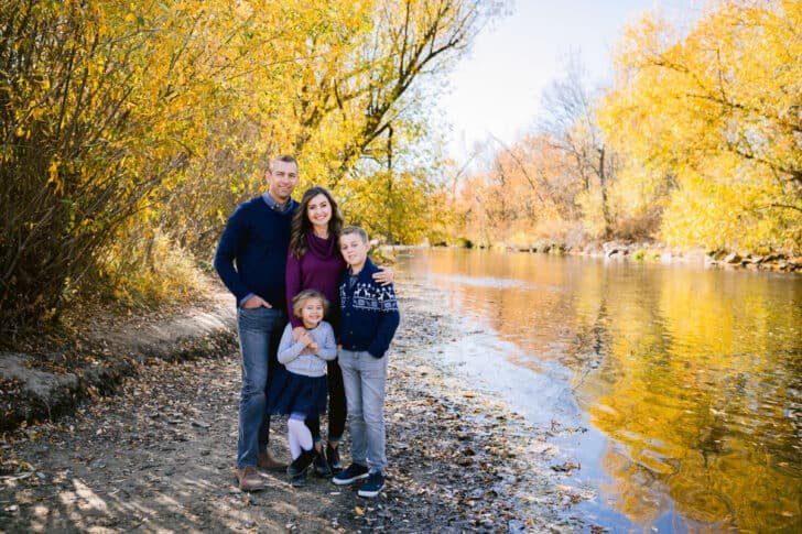 A photo of a family standing by a river. 