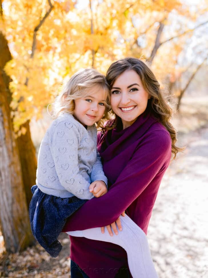 A little girl begin held by her mother. 