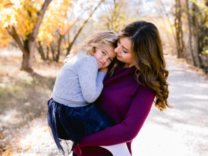 A little girl being snuggled by her mother. 