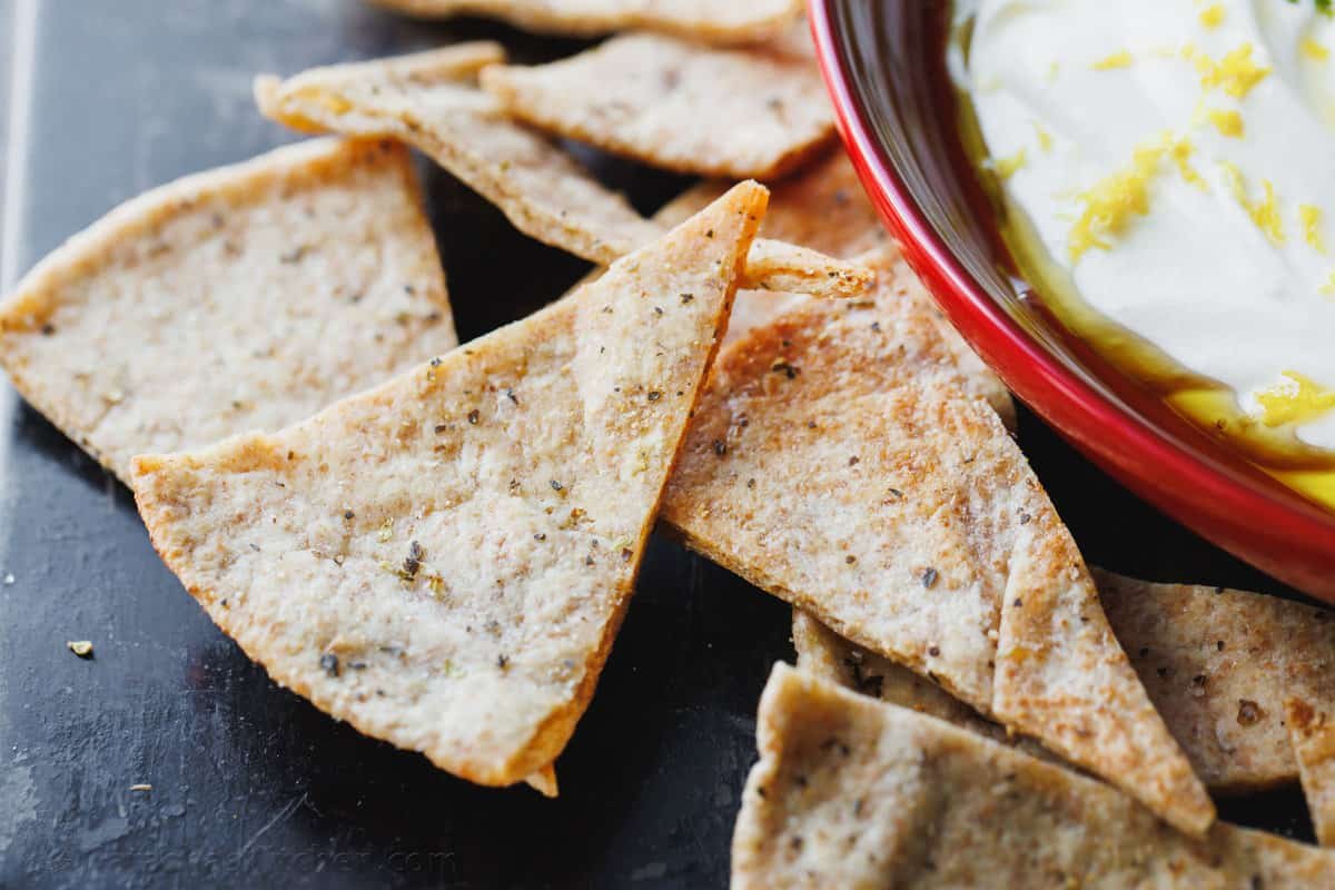Homemade pita chips are a great way to use leftover pita bread. Crisp, crunchy, perfectly seasoned and more satisfying than store-bought. Serving pita chips with dip