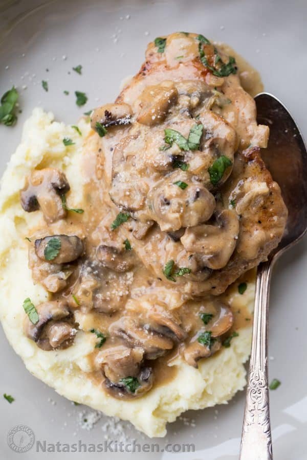 Smothered pork chops in mushroom sauce served over mashed potatoes