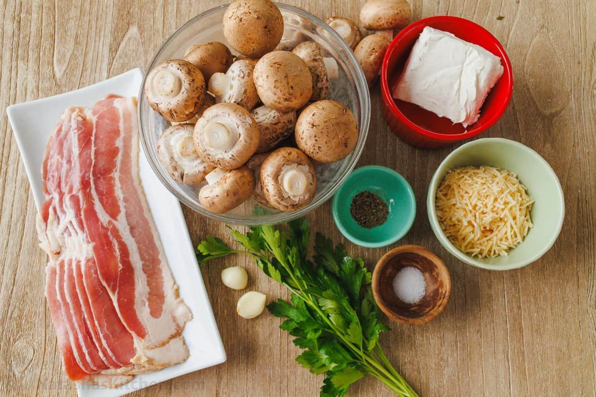 This is the best stuffed mushrooms recipe for your next party. The bite-sized appetizer is stuffed with cream cheese, bacon bites and garlic. Ingredients for champignons including baby bella, bacon, cream cheese, Parmesan cheese, salt and pepper, parsley and garlic