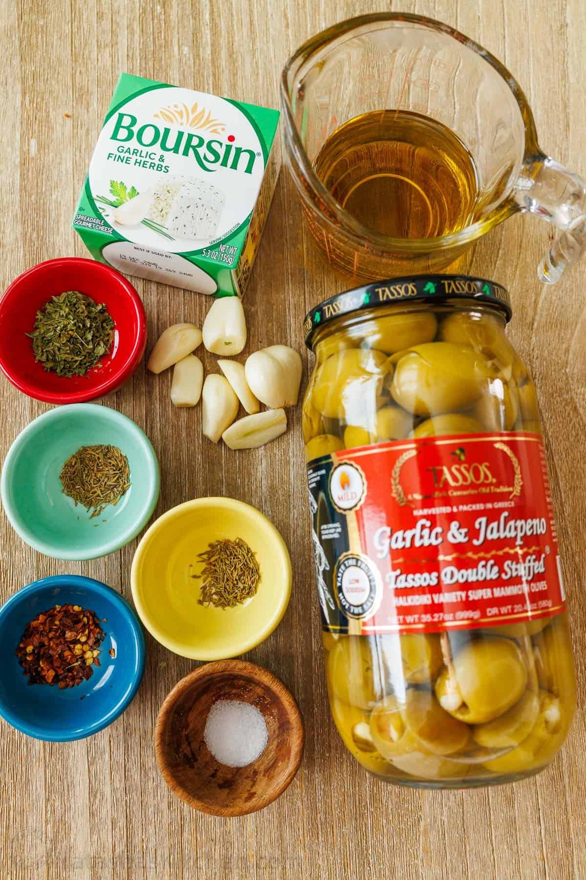 Ingredients for Stuffed Olives, including green olives, extra virgin olive oil, minced garlic, dried parsley, red chili flakes, dried thyme, dried rosemary, fine sea salt, and Garlic and Herb Boursin Cheese. Ingredients for Stuffed Olives, including green olives, extra virgin olive oil, minced garlic, dried parsley, red chili flakes, dried thyme, dried rosemary, fine sea salt, and Garlic and Herb Boursin Cheese.