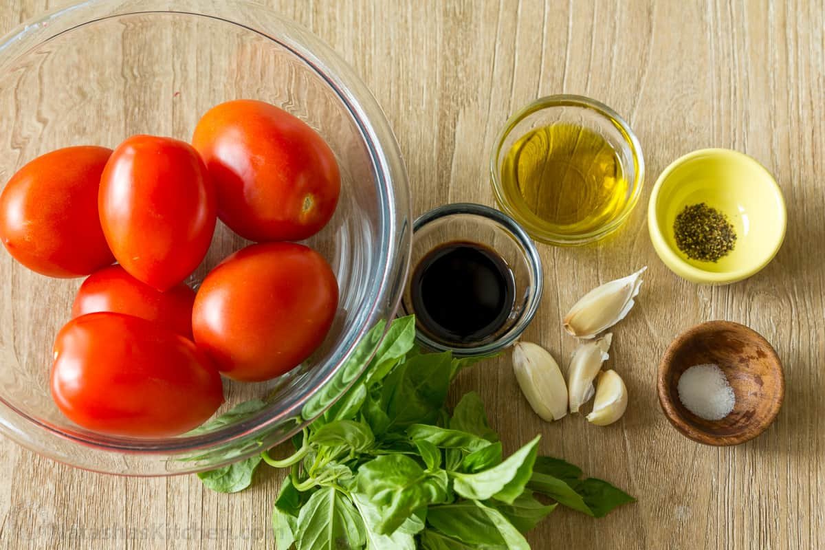 Ingredients for tomato bruschetta with roma tomatoes, basil, oil, balsamic, salt and pepper