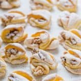 Meringue Shell Cookies have a crisp ribbon of meringue and soft crumbly center. These walnut meringue cookies are completely irresistible Christmas cookies! | natashaskitchen.com