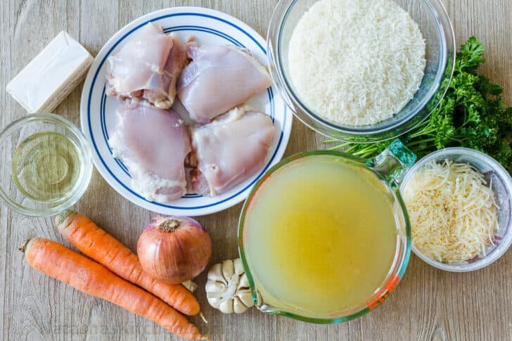 Ingredients for chicken and rice with chicken, rice, broth, cheese, carrots, onion, garlic