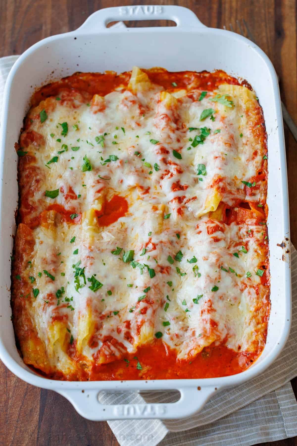 Our Stuffed Manicotti recipe has three kinds of cheese stuffed into perfectly cooked pasta, smothered in marinara sauce, and baked perfectly. Learn how to make the best stuffed manicotti! Manicotti recipe with three cheeses and marinara sauce