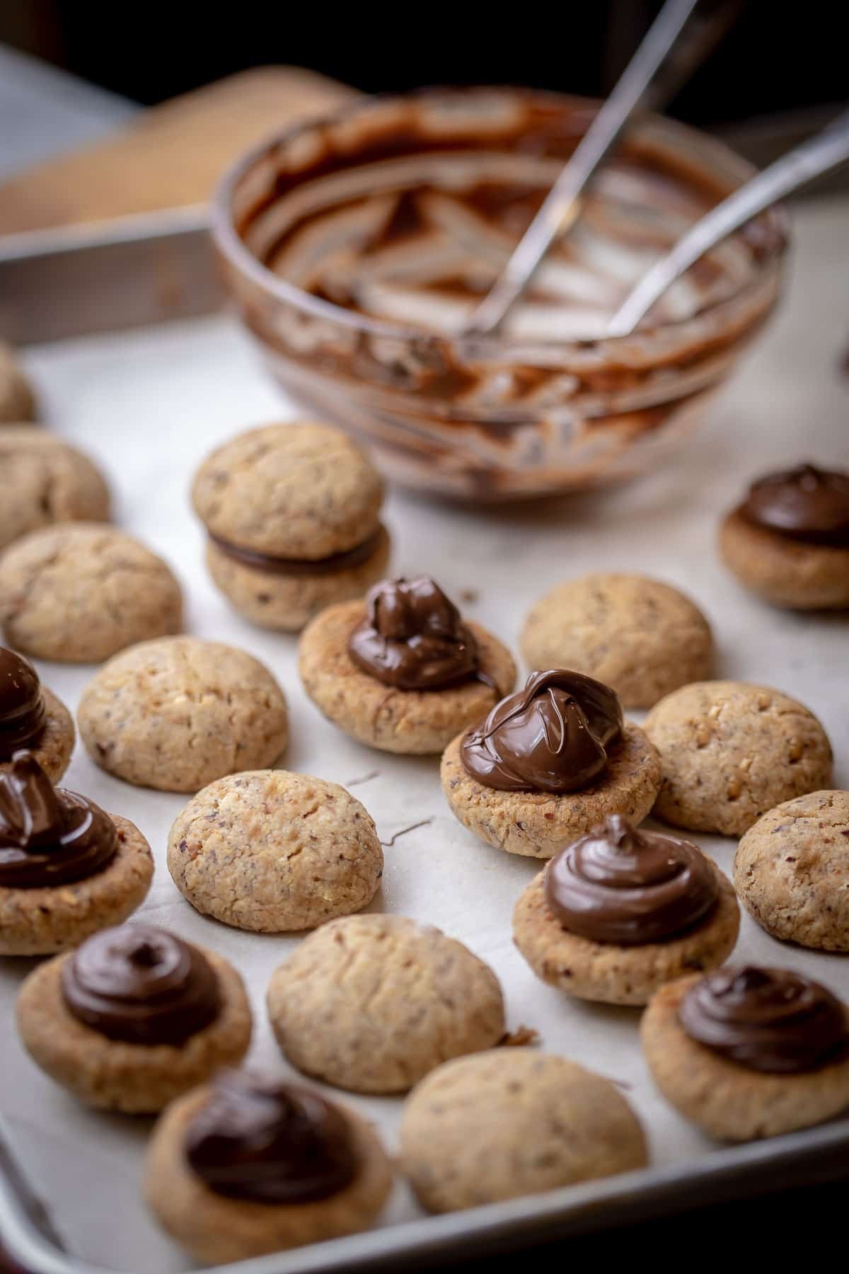 Italian Cookies Baci di Dama a.k.a. lady kisses are filled with chocolate. These cookies are beautiful and irresistibly good. #Italiancookies #bacididama #cookies #sandwichcookies Italian Cookies Baci di Dama are made with two melt-in-your-mouth hazelnut cookies held together with a good dollop of dark chocolate.