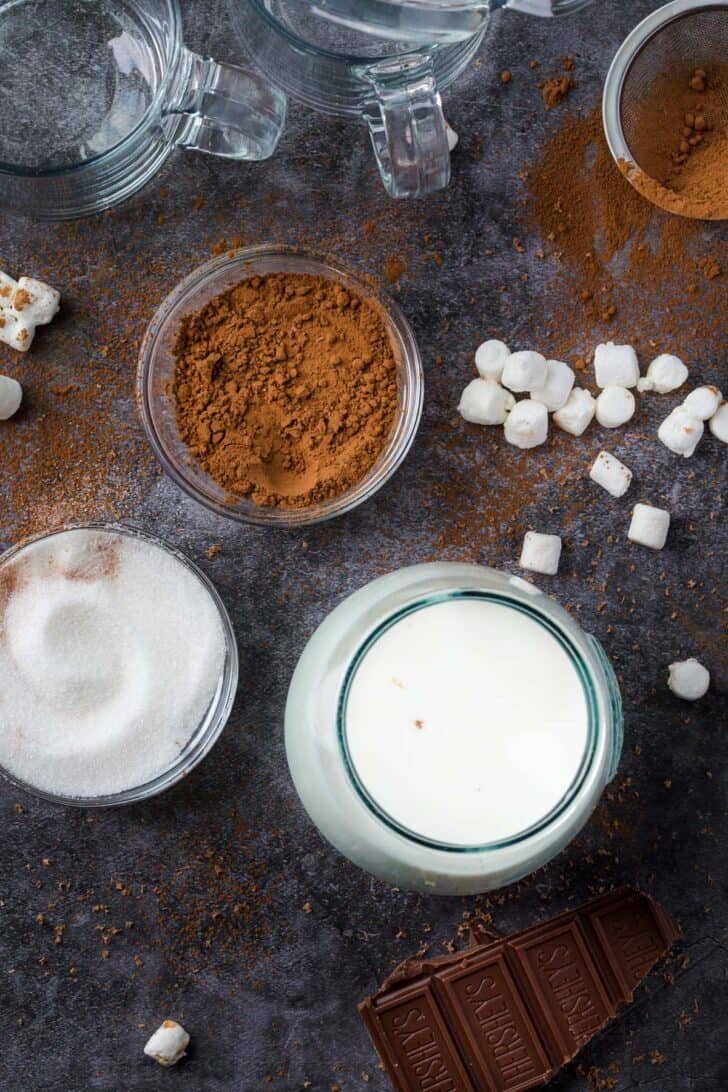 The easiest homemade hot chocolate with 5 simple ingredients ready in minutes and makes for the BEST drink during the colder weather. Hot chocolate ingredients on platter with sugar, milk and cocoa powder.