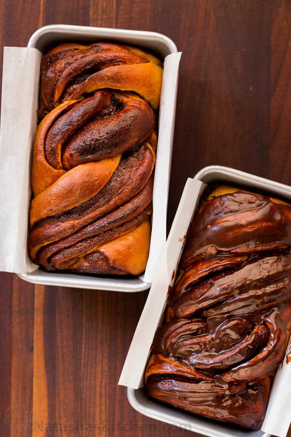 This homemade Chocolate Babka is a buttery bread loaf swirled with decadent ribbons of chocolate ganache. The ultimate breakfast or dessert! Overhead view of two chocolate babka loaves in two lined loaf pans.