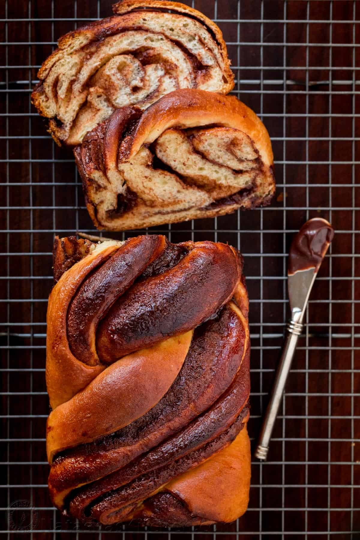 This homemade Chocolate Babka is a buttery bread loaf swirled with decadent ribbons of chocolate ganache. The ultimate breakfast or dessert! Overhead view of chocolate babka with two slices cut from one end.