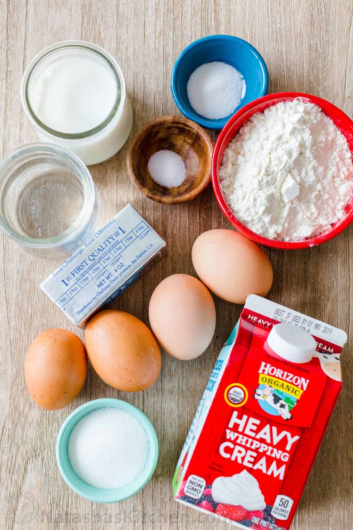 Cream Puffs are a classic French dessert filled with sweet cream and dusted with powdered sugar. Learn how to make easy bakery quality cream puffs. #creampuffs #creampuffrecipe #chouxpastry #chouxpaste #dessert #pastry #Frenchpastry #French #natashaskitchen Ingredients for cream puffs recipe