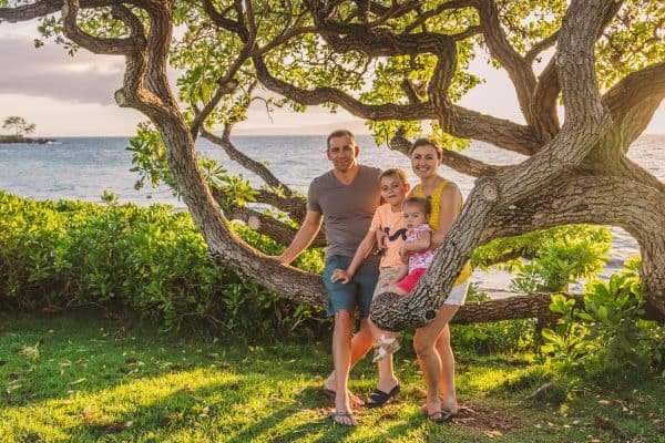 A family sitting on a tree branch 