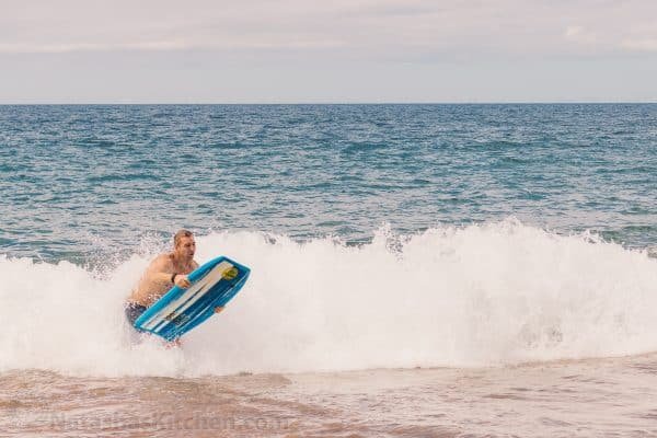 A man riding a wave on a Boogie board in the ocean