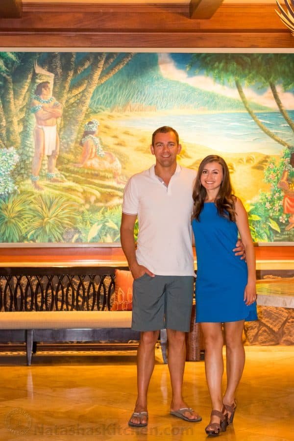Natasha and her husband standing in front of a bench and painting