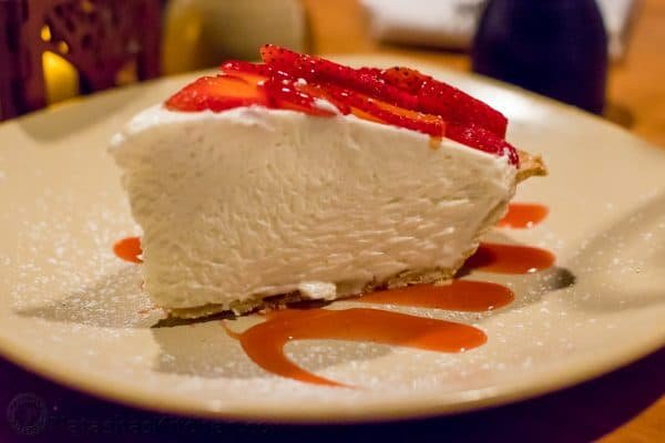 A piece of cake on a plate with strawberries on top