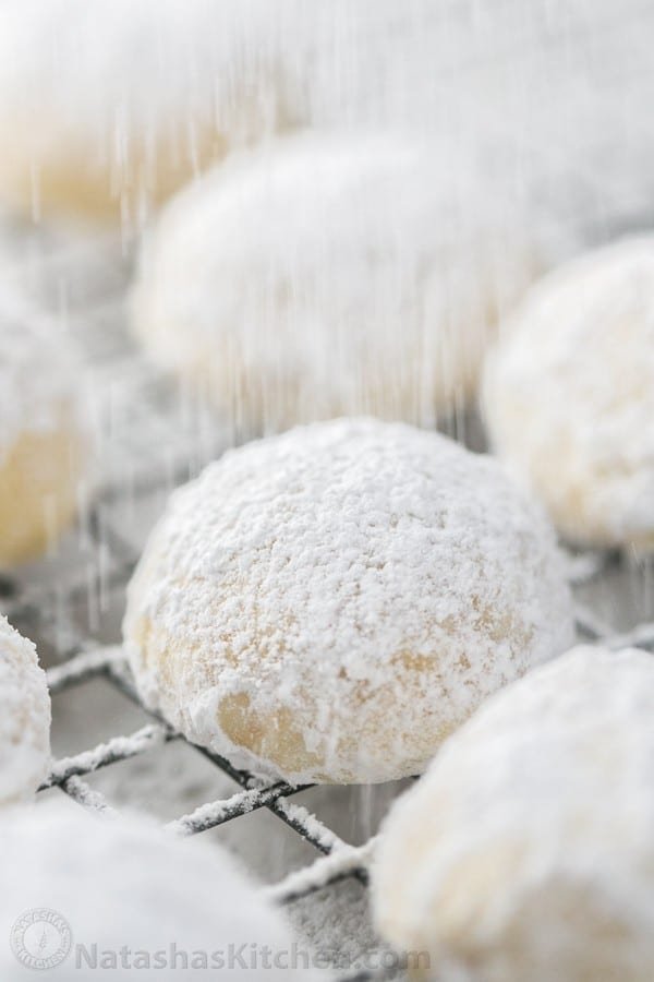 These almond snowball cookies just melt in your mouth. Perfect Christmas cookies since they look like darling little snowballs. Dusting snowball cookie recipe with extra powdered sugar