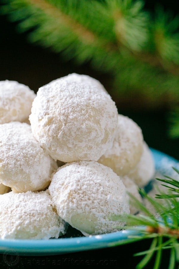 These almond snowball cookies just melt in your mouth. Perfect Christmas cookies since they look like darling little snowballs. Snowball Christmas Cookies on a platter