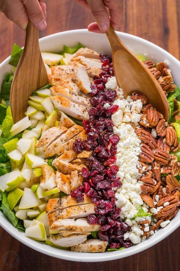 A bowl of autumn chopped chicken salad with two wooden spoons in the bowl
